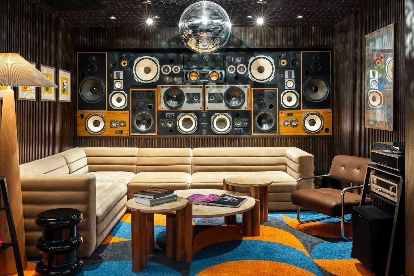 Music themed lounge room with a disco ball, high-tech speakers, and comfortable couches.